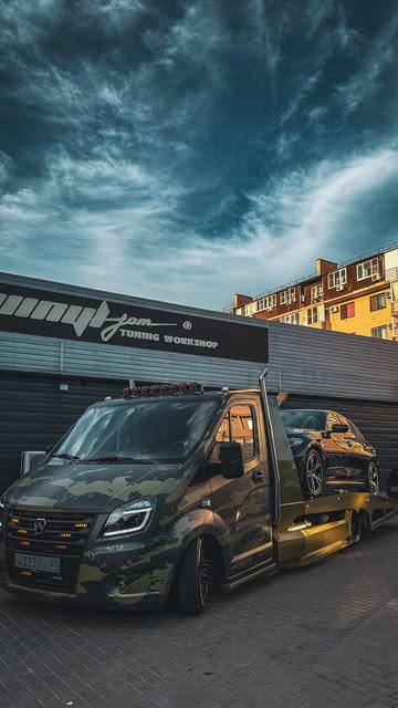 Перевозка автомобиля на эвакуаторе у автомастерской